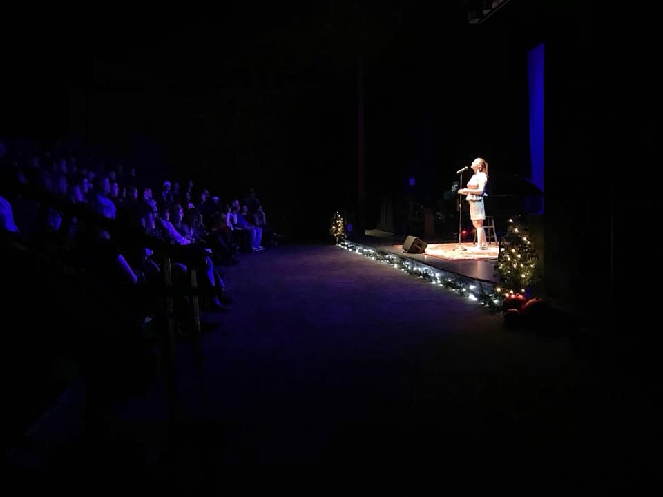 Singer on a darkened theater stage